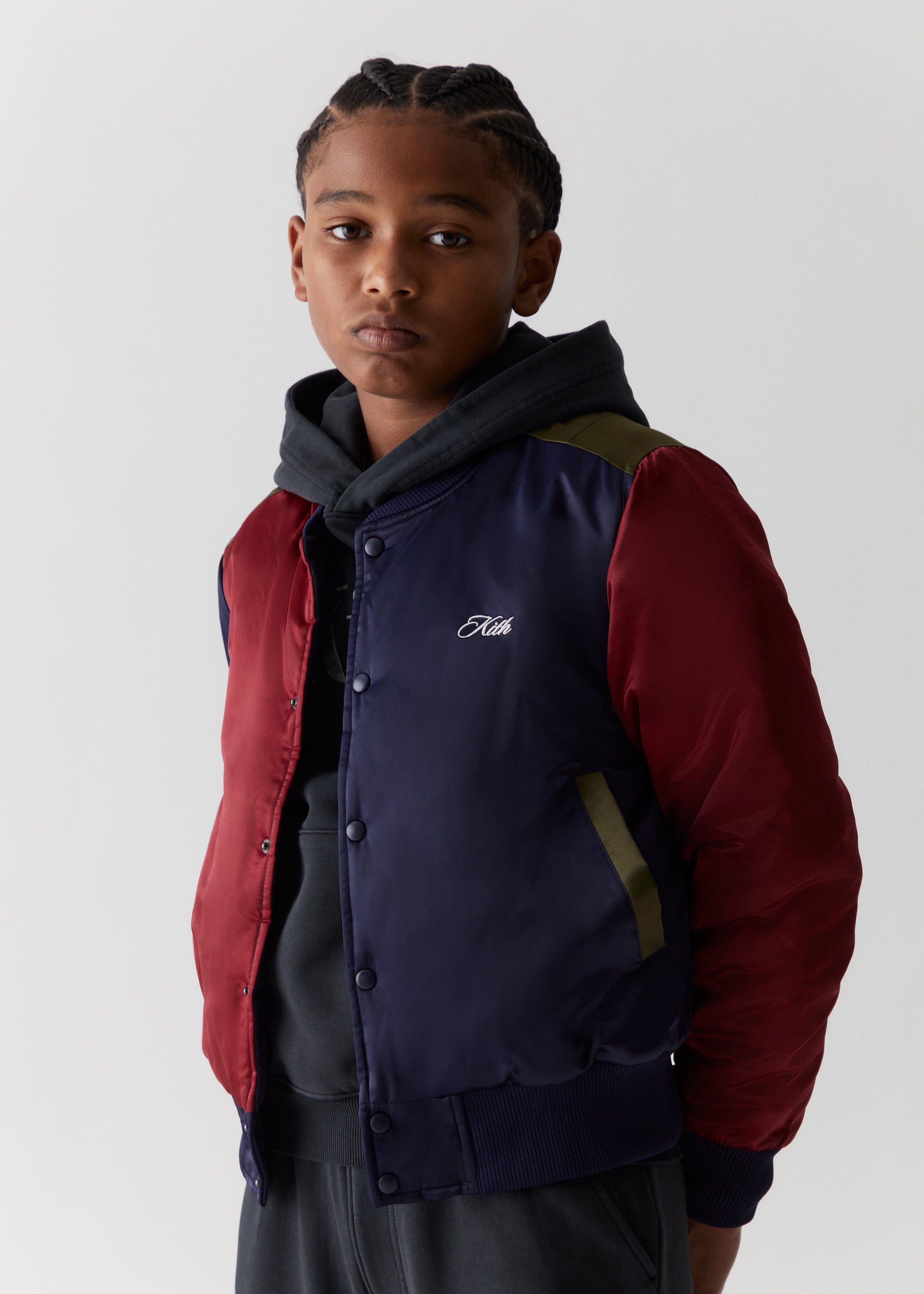 A child wearing a color-blocked varsity jacket from the Kith Kids Fall Classics 2023 collection.